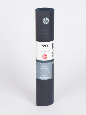 Manduka PROlite yoga mat in midnight color, rolled up, front view on a white background, textured, professional quality, eco-friendly, non-slip surface.