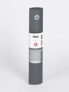 Manduka PRO Lite Thunder Gray Yoga Mat, rolled front view with logo and packaging, non-slip surface, high-performance, eco-friendly exercise mat.